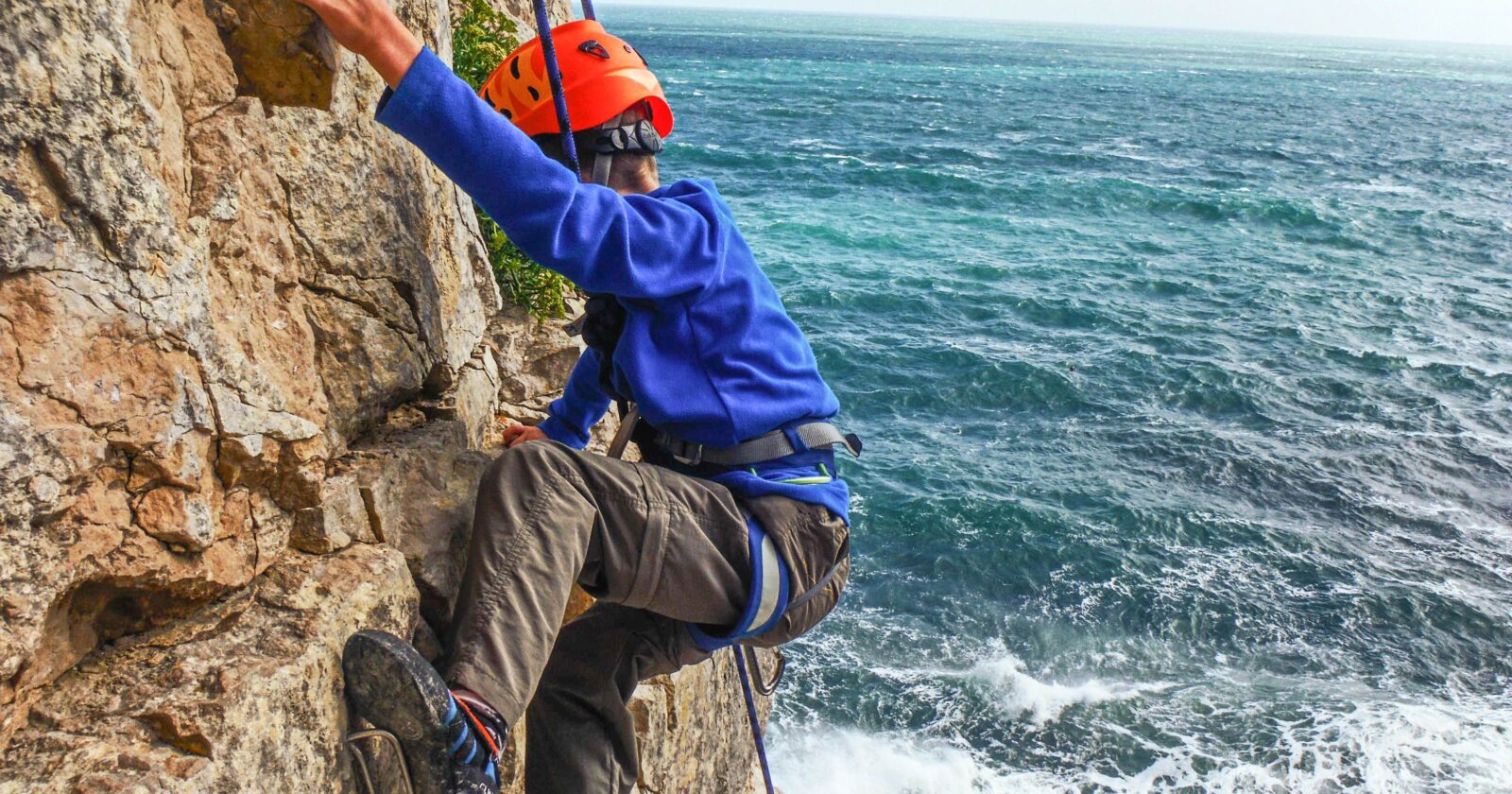 Child climbing on the Dorset coast