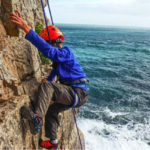 Boy climbing jurassic cliffs