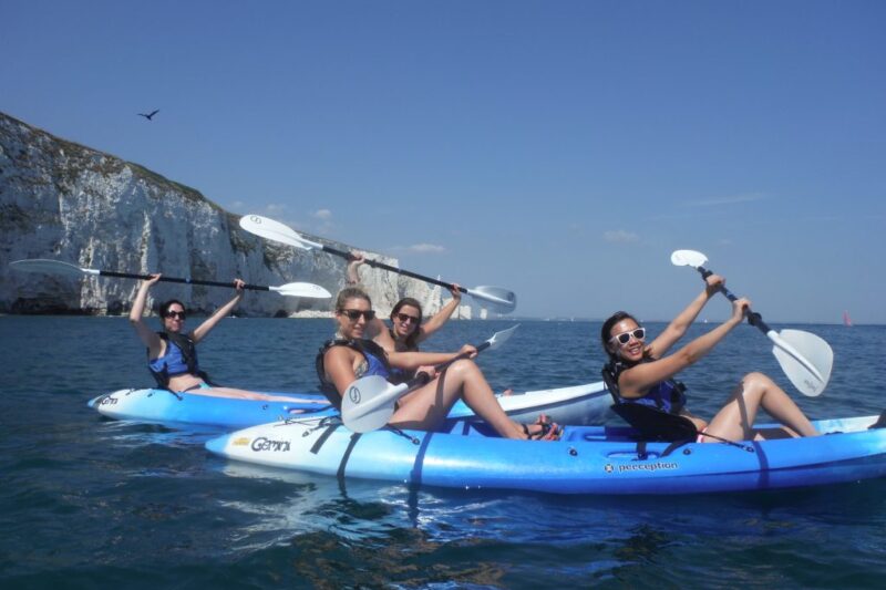 Hen party kayaking with oars raised and Old Harry white rocks behind