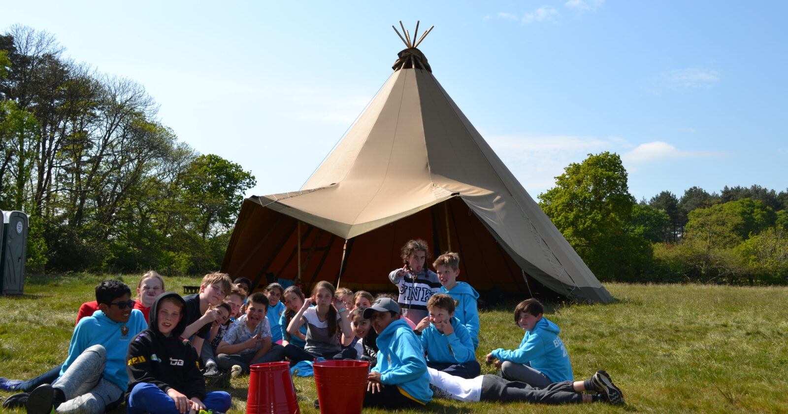 School group photo outside the central tipi