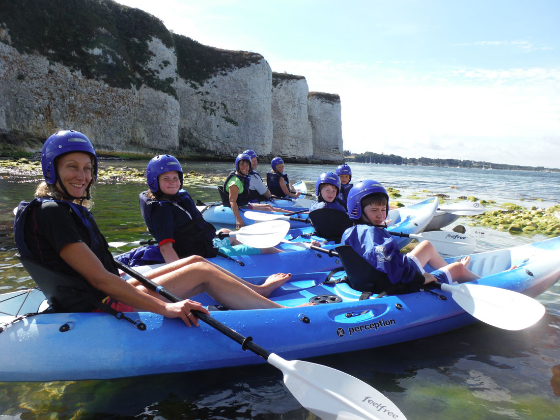 Family group kayaking close to Old Harry Rocks on the Jurassic Coast