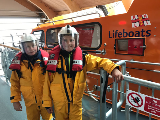 Students experiencing RNLI suits on the lifeboat in Swanage