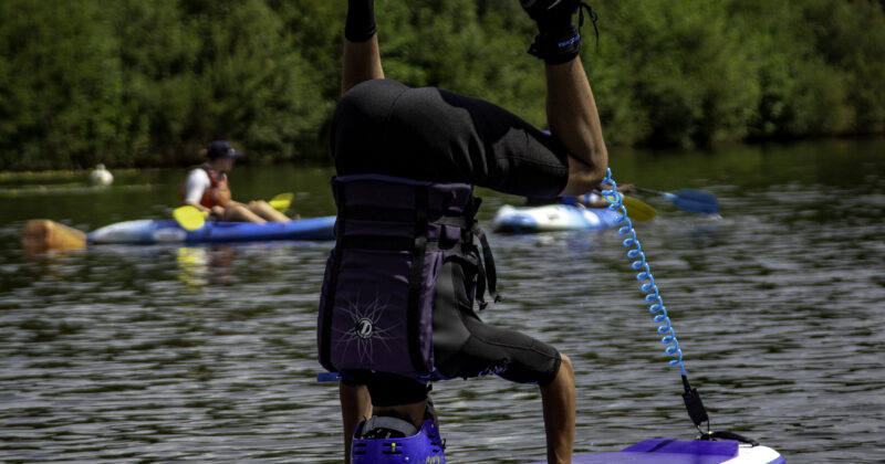 boy head stand on stand up paddleboard dorset