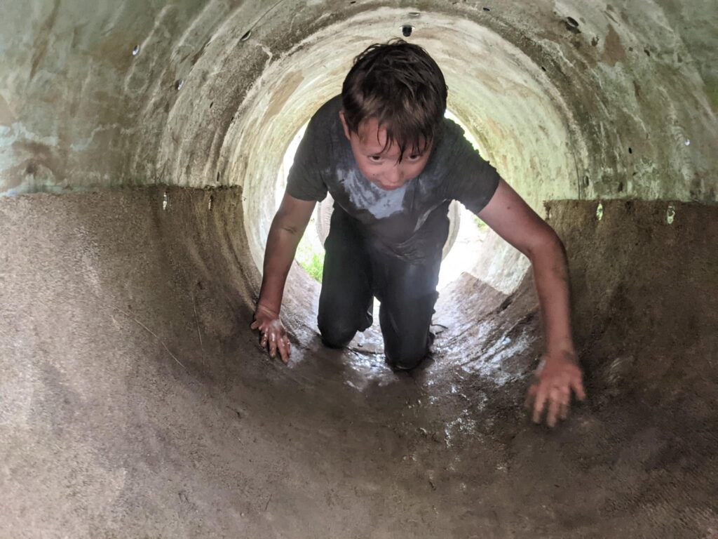 boy climbing through tunnel dorset mud trail