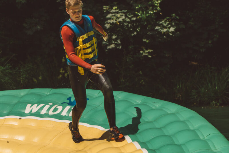 boy running on inflatable waterpark in dorset