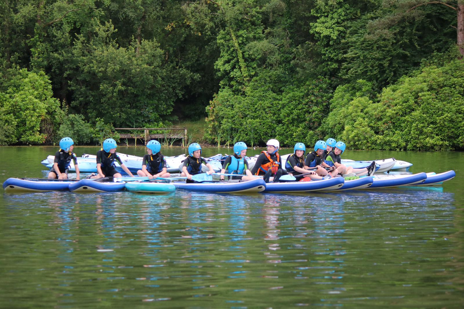 children sat on stand up paddleboards