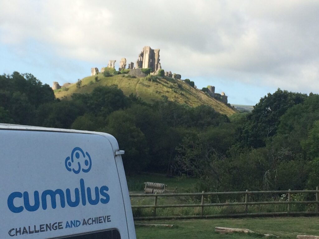 cumulus outdoors minibus next to corfe castle