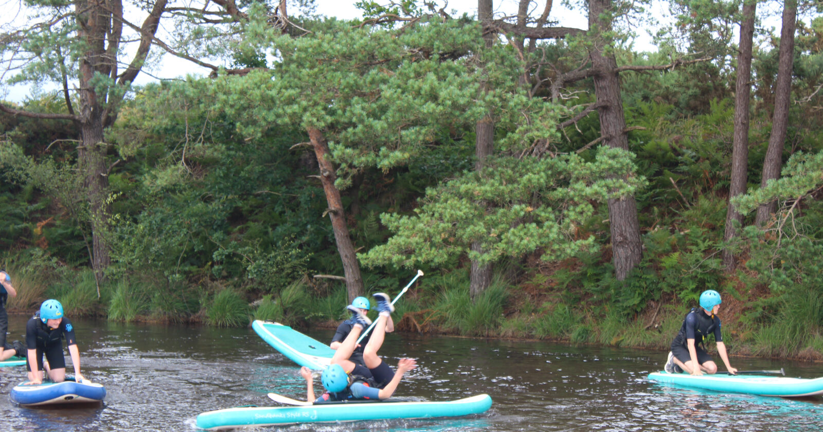 DofE Summer Gold Residential participant trying a forward roll on stand up paddle