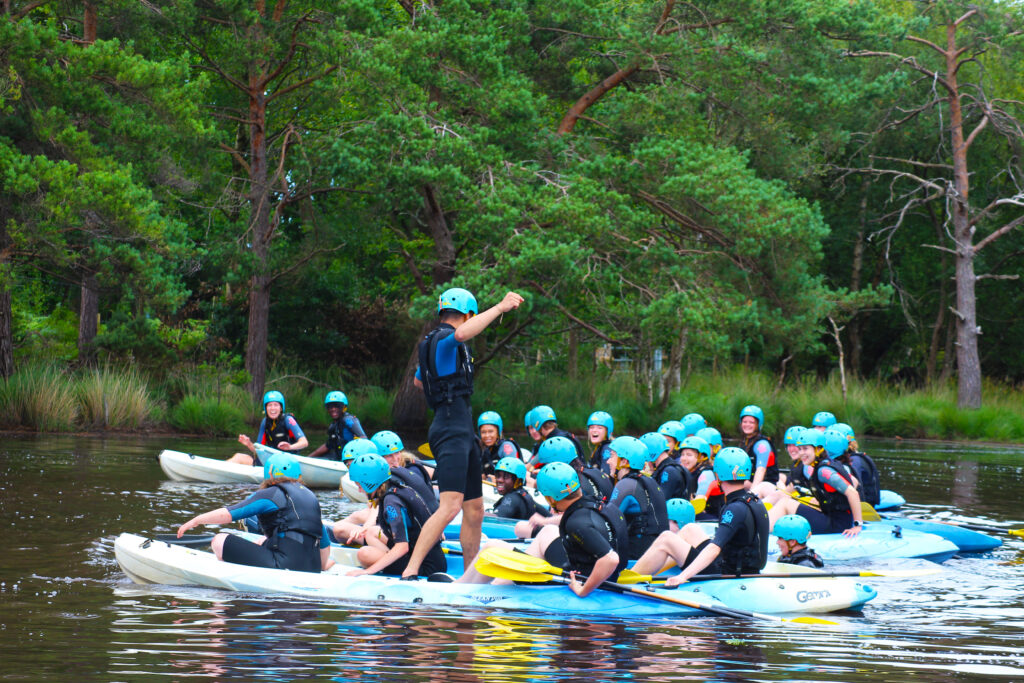 DofE Summer Gold Residential participants standing up on kayaks